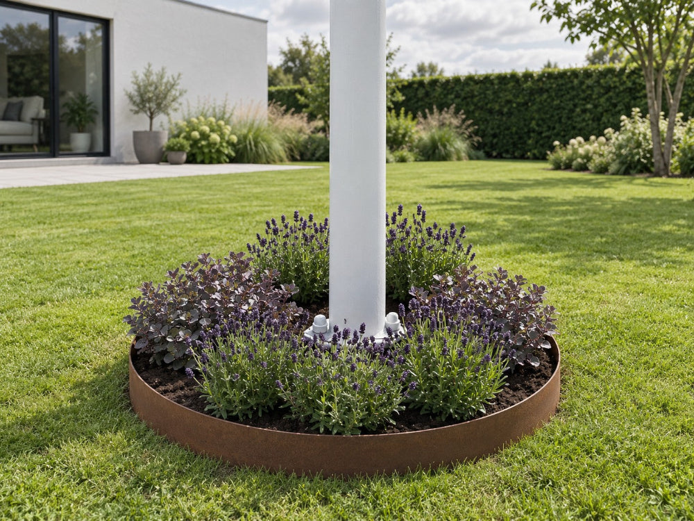Hvid flagstang ved hvidt hus med lavendel i cortenståls bedring