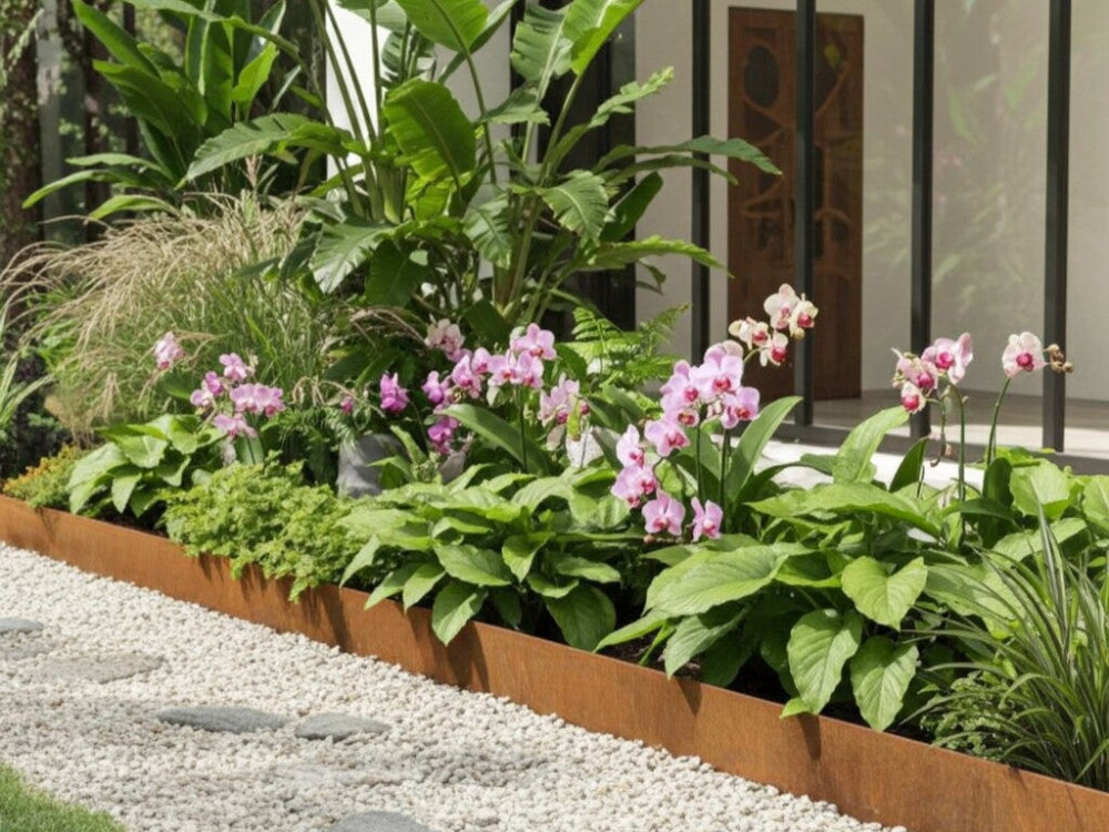 Bedkant i cortenstål med tropiske planter og blomster langs terrasse