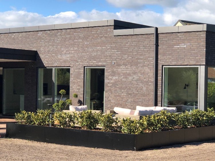 byJEMA CUBY højbede i sortlakeret stål på specialmål omkring terrasse ved moderne villa