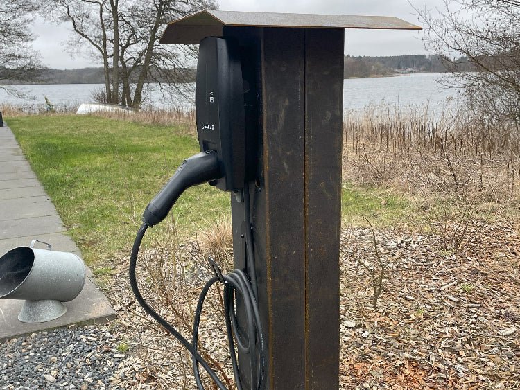 byJEMA ladestander i cortenstål set fra skrå vinkel med integreret kabelophæng