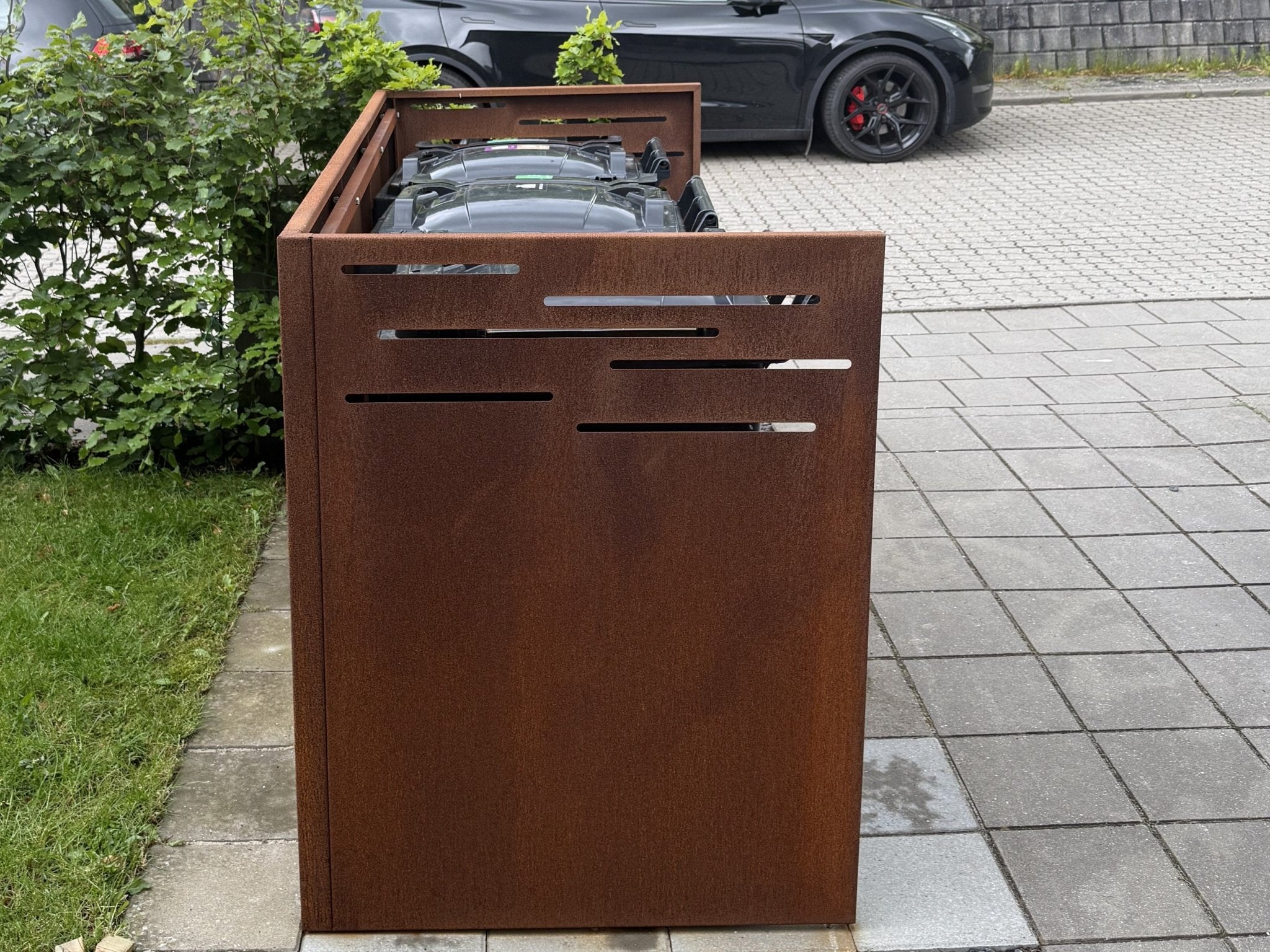 Frontvisning af byJEMA skraldespandsskjuler i cortenstål med dekorative ventilationsudskæringer