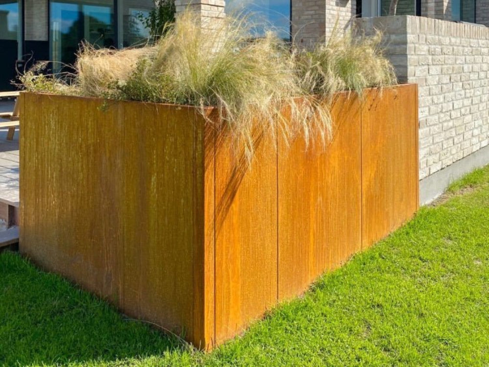 Stor CUBY plantekasse i cortenstål brugt som hjørnebed i moderne have