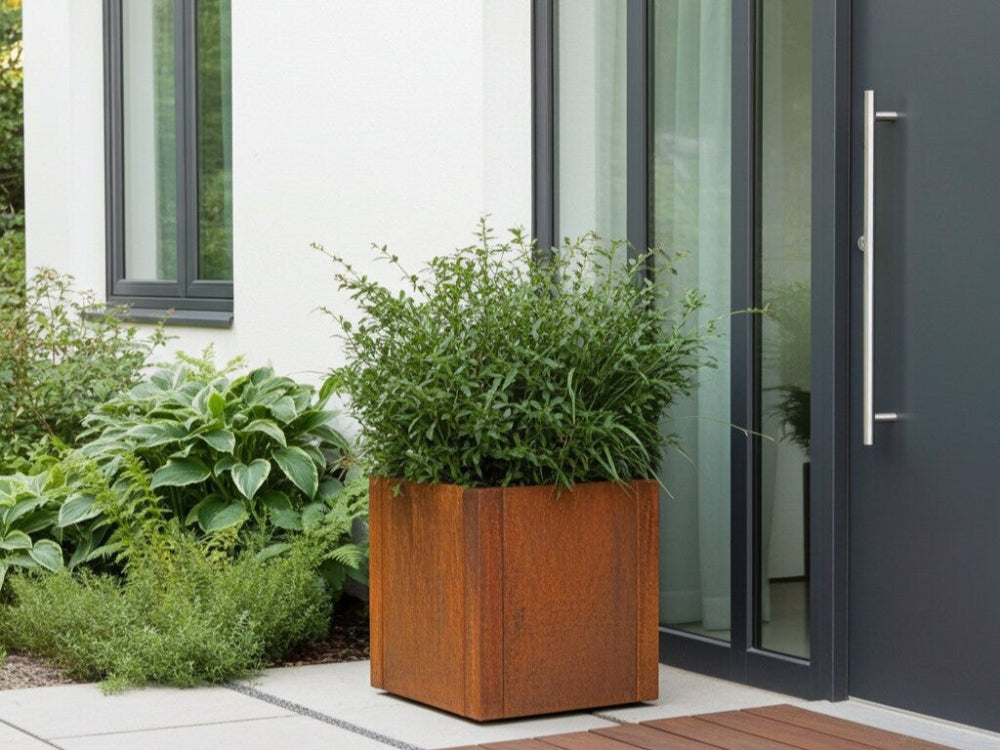 Kvadratisk plantekasse i cortenstål fra CUBY placeret ved husets indgang