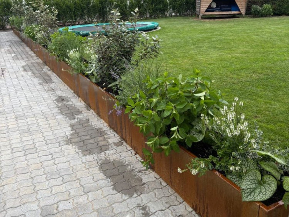 CUBY plantekasse i cortenstål brugt som plantebed langs havegang