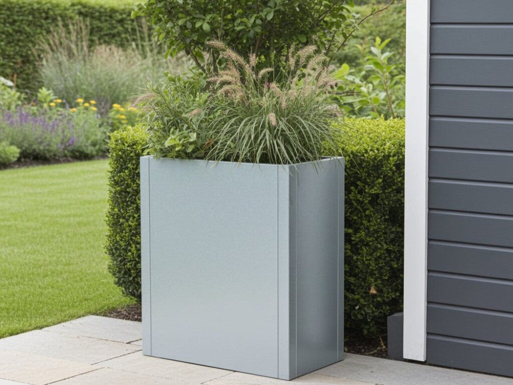 CUBY høj aflang plantekasse i galvaniseret stål med prydgræsser ved moderne facade