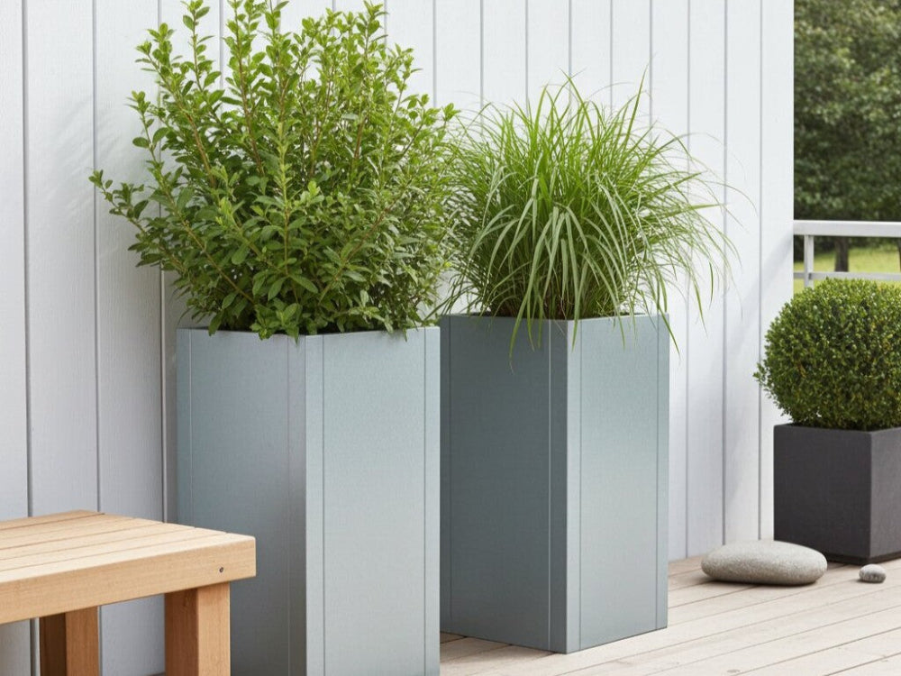 CUBY plantekasse i galvaniseret stål placeret på moderne terrasse med grønne planter