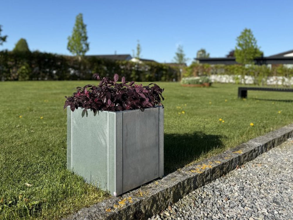 CUBY lav kvadratisk plantekasse i galvaniseret stål placeret på græs ved kantsten