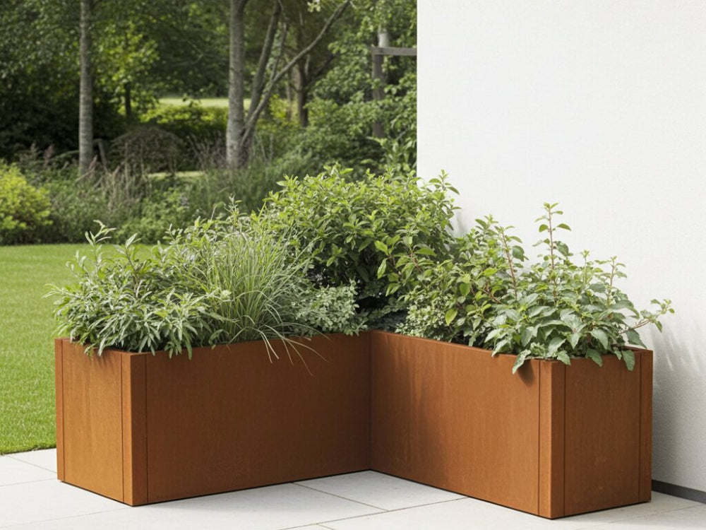 CUBY vinkelplantekasse i cortenstål fyldt med blomster og prydgræs