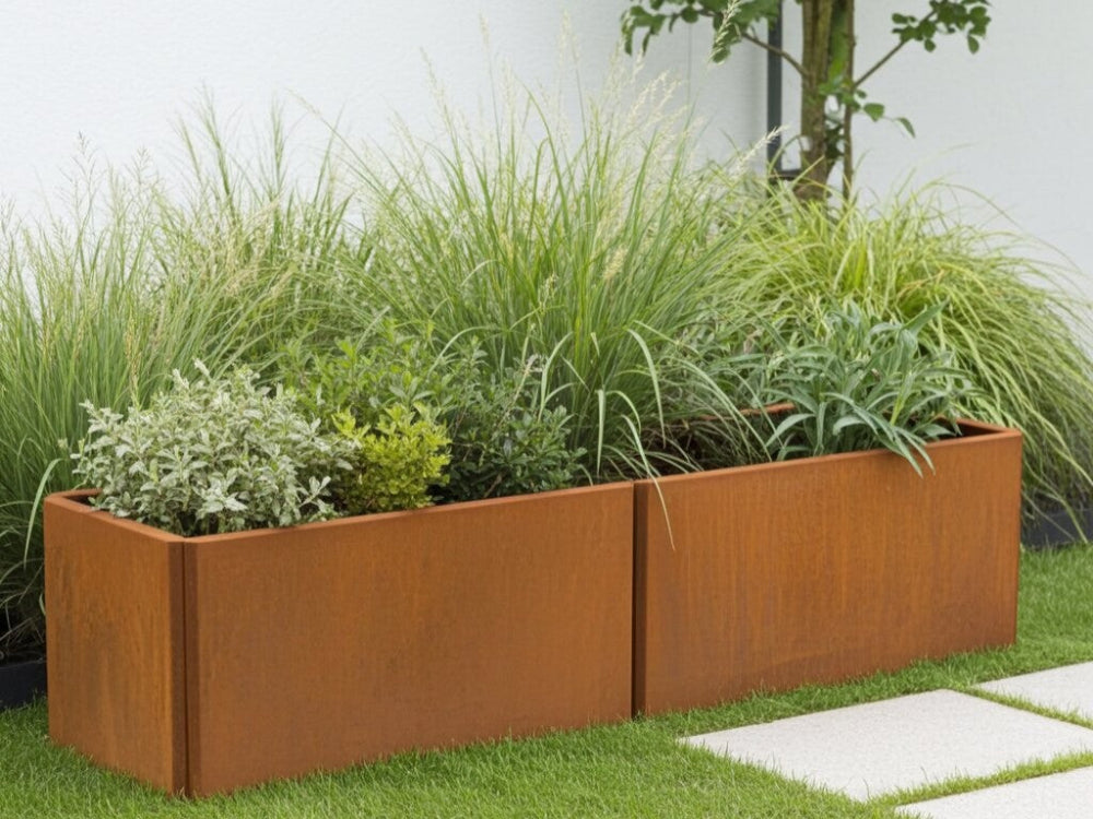 EDGY aflang lav plantekasse i cortenstål med prydgræsser i moderne have