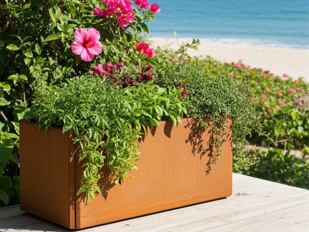 EDGY kompakt plantekasse i cortenstål med blomster ved terrasse