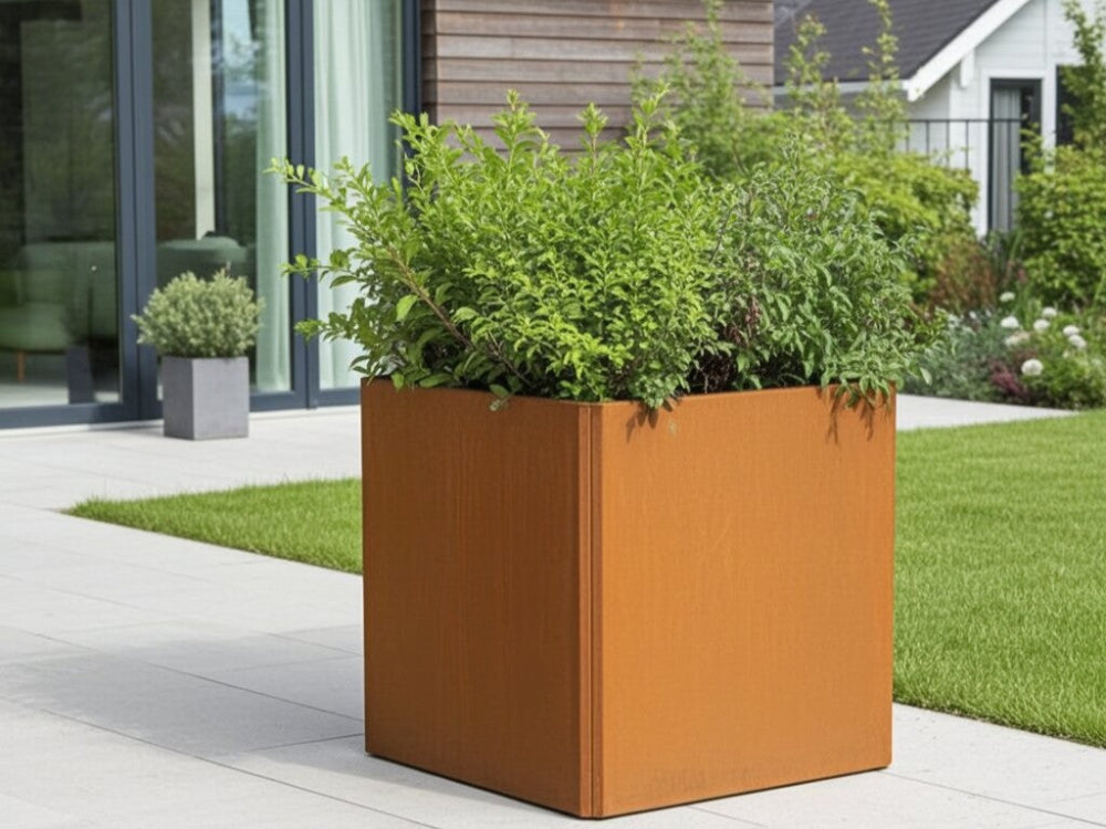 EDGY kvadratisk høj plantekasse i cortenstål med grøn beplantning ved terrasse