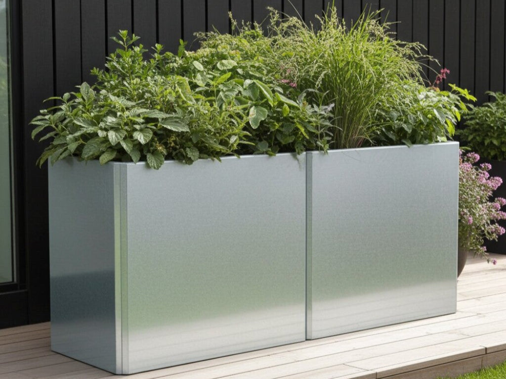 To sammenkoblede EDGY plantekasser i galvaniseret stål med frodig beplantning ved sort træfacade