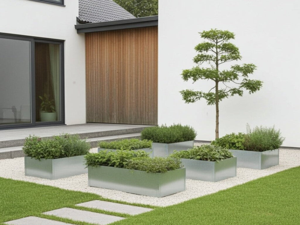 Galvaniserede højbed i stål med stauder og urter i struktureret haveanlæg ved moderne bolig