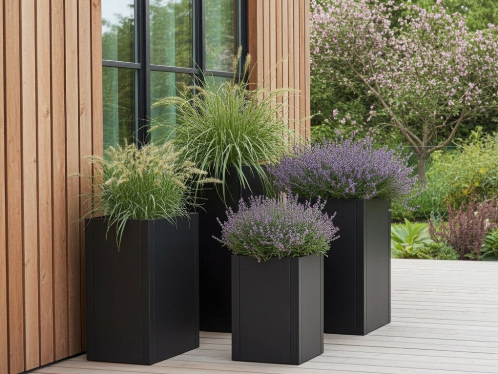 Høje plantekrukker i sort stål med prydgræsser og lavendel
