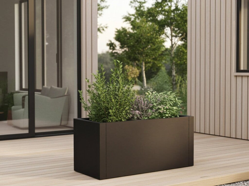 Sort plantekasse i stål med buske og stauder på moderne træterrasse