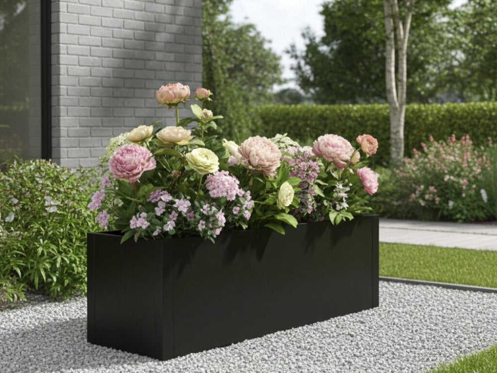 Sort plantekasse i stål med blomstrende stauder i moderne have