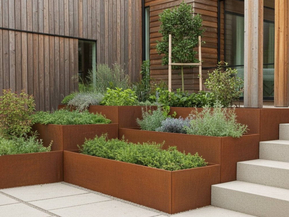 Støttemur i cortenstål omkring terrasserede plantebede ved træfacade