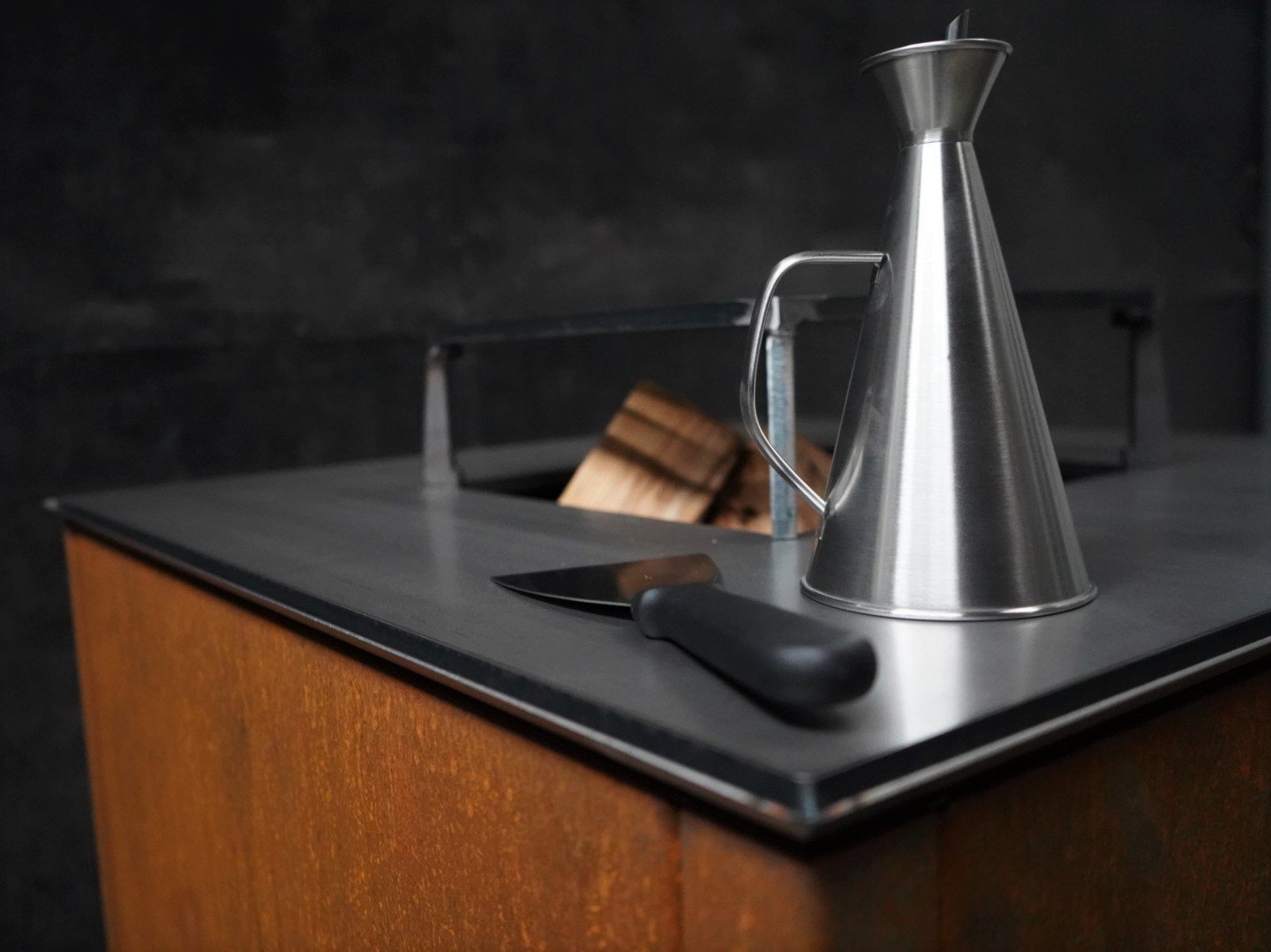 Detaljebillede af byJEMA bålgrill i cortenstål med sort stål topplade – robust udendørs ildsted i minimalistisk design