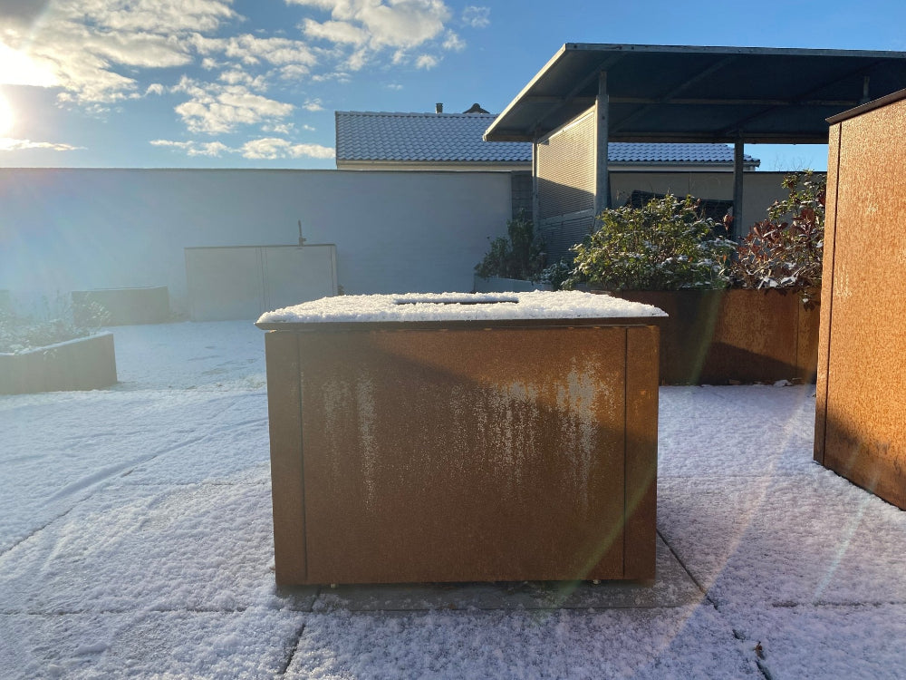 CUBY bålgrill i cortenstål dækket af sne på terrasse