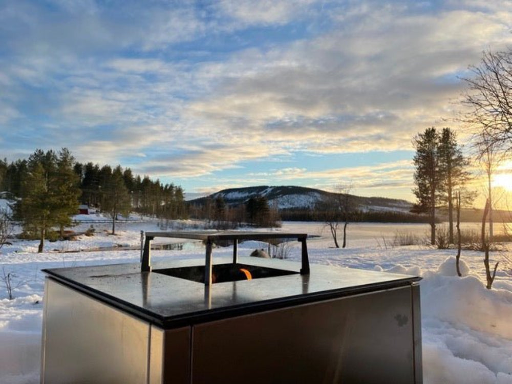 CUBY bålgrill i galvaniseret stål i snedækket landskab