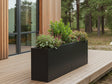 byJEMA CUBY plantekasse i sortlakeret stål på specialmål med planter på moderne træterrasse