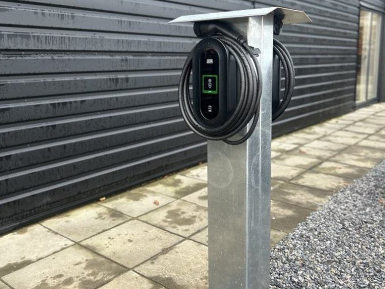 byJEMA ladestander i galvaniseret stål monteret ved mørk facade