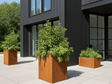 byJEMA CUBY plantekasse i cortenstål 40 x 40 x 80 cm med grønne planter på moderne terrasse