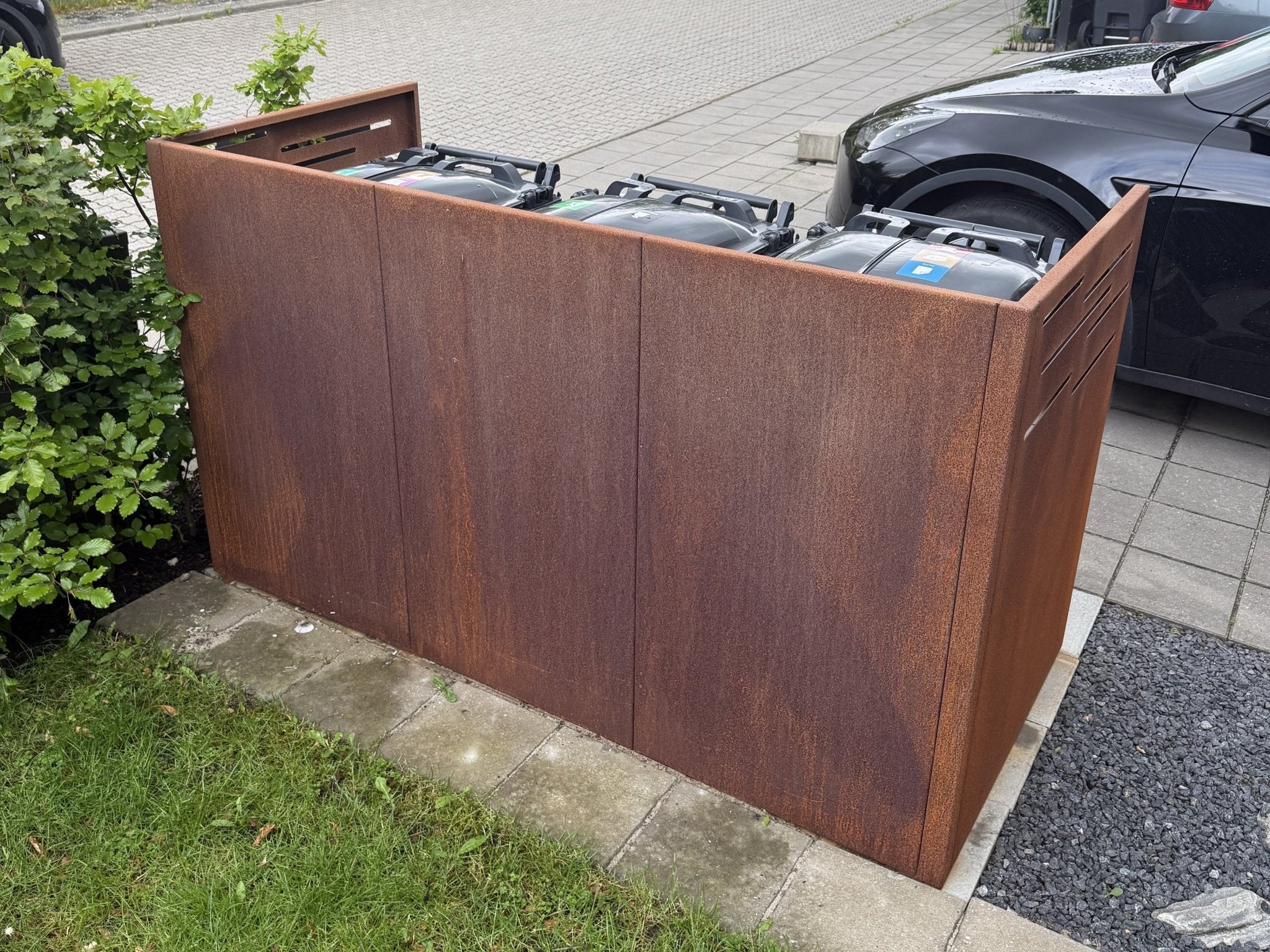 byJEMA skraldespandsskjuler i cortenstål set bagfra med skjulte affaldsbeholdere