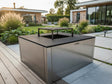 CUBY bålgrill i galvaniseret stål i stilren designhave med terrasse og beplantning