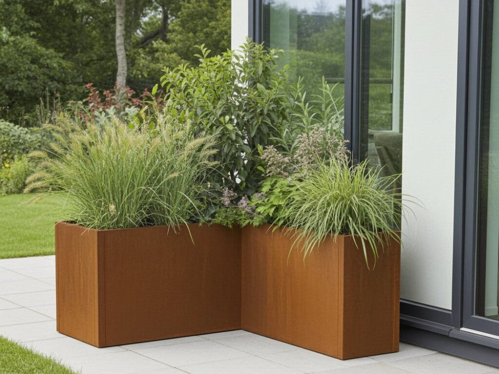 CUBY plantekasse i cortenstål formet som hjørnebed med prydgræs og buske
