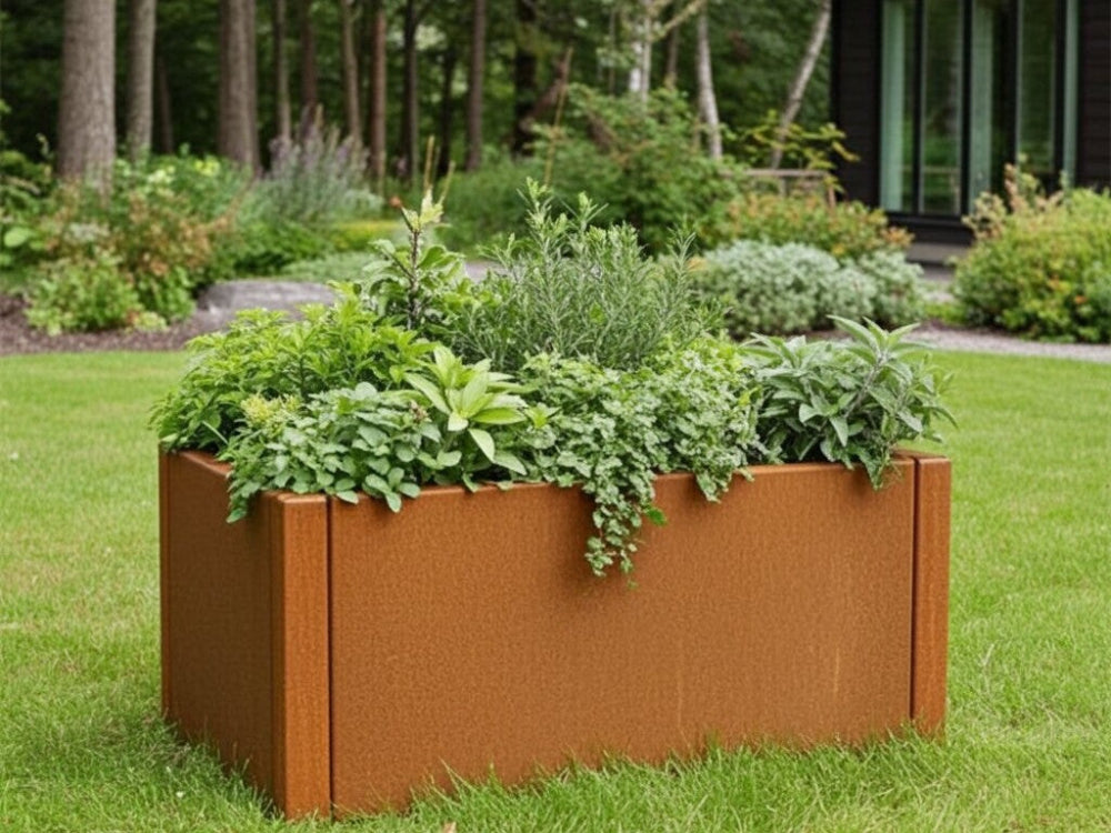CUBY plantekasse i cortenstål med frodige krydderurter placeret i grøn have