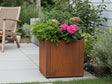 Kvadratisk CUBY plantekasse i cortenstål med hortensia og grønne planter ved terrasse