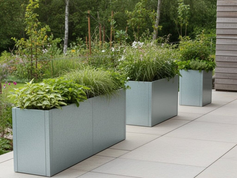 CUBY plantekasser i galvaniseret stål med grønne stauder langs terrasse