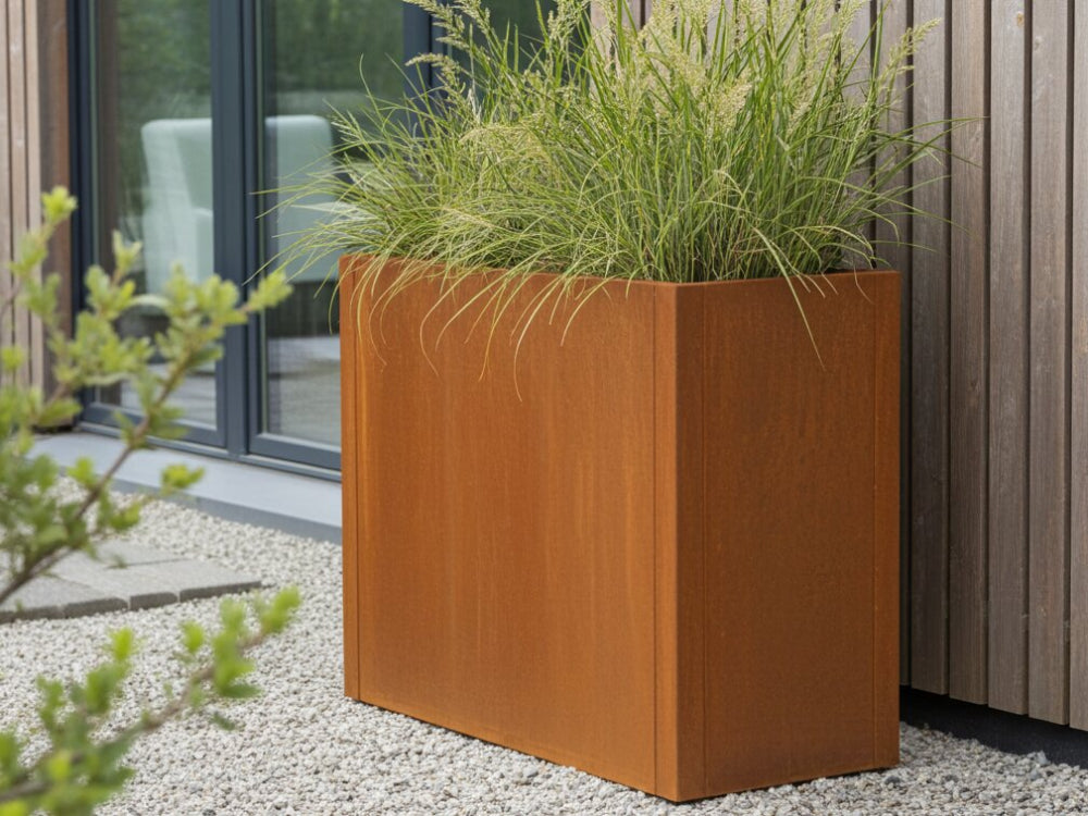 Høj CUBY plantekasse i cortenstål med prydgræs ved moderne træfacade