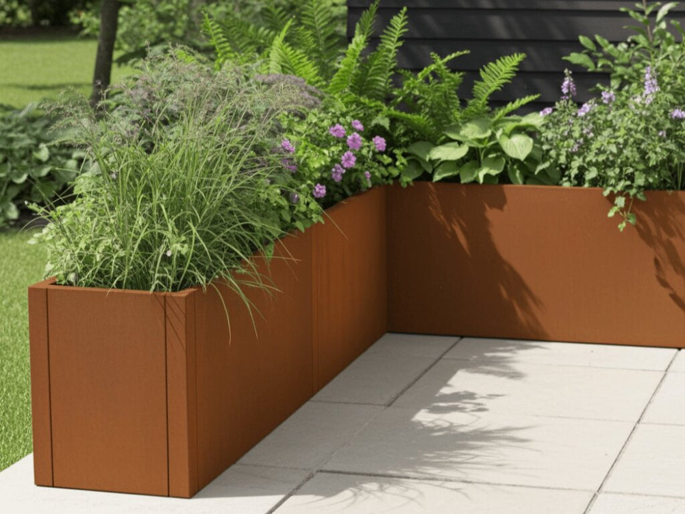 L-formet CUBY plantekasse i cortenstål med blomster og græsser i frodig have