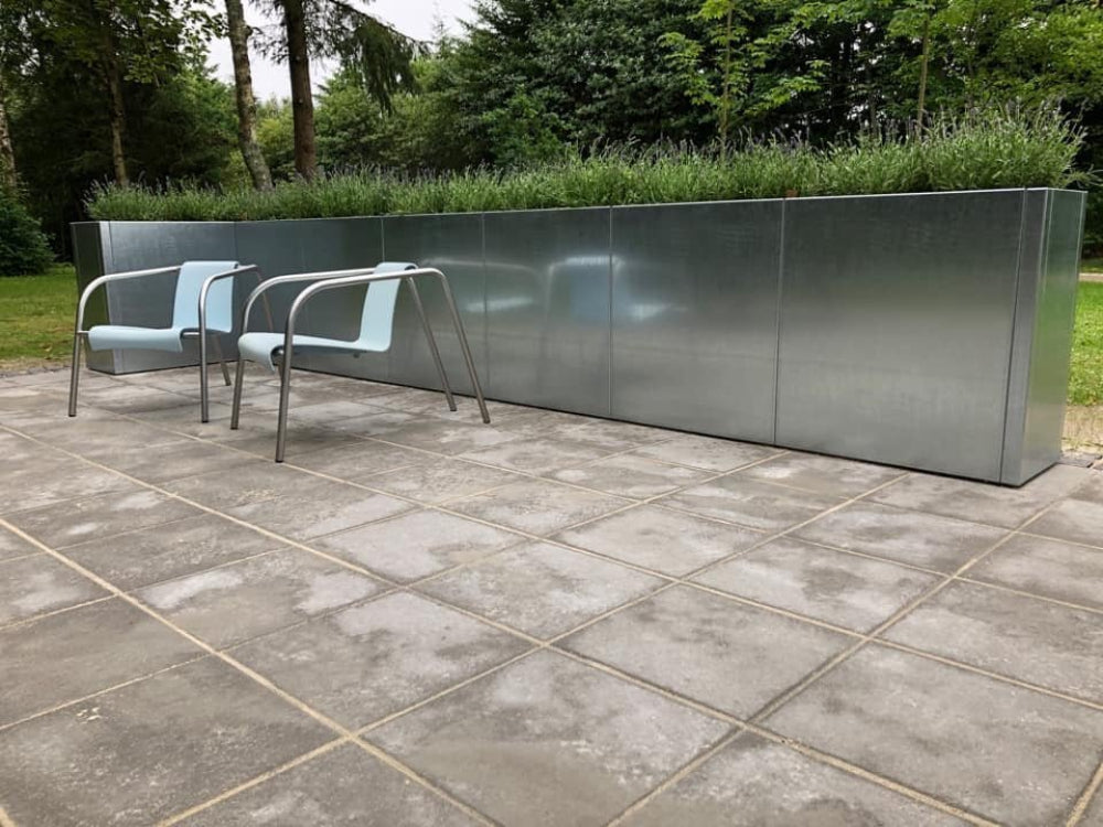 Lang CUBY plantekasse i galvaniseret stål med græsser ved terrasse