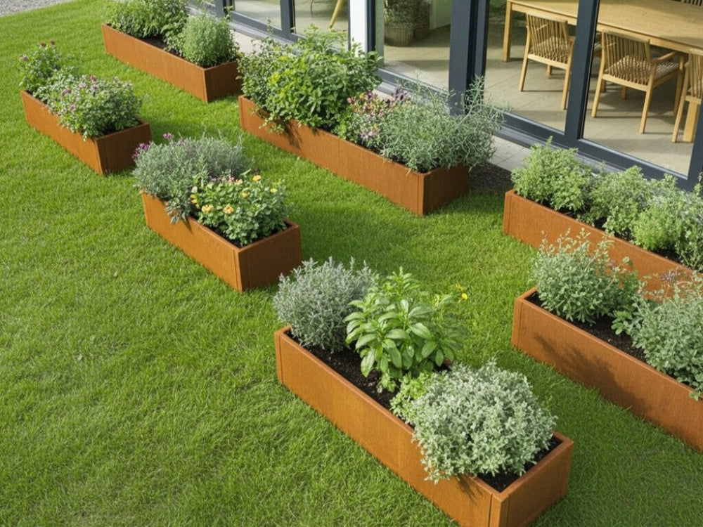 Flere CUBY plantekasser i cortenstål med forskellige planter i græsplæne