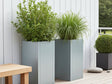 CUBY plantekasse i galvaniseret stål placeret på moderne terrasse med grønne planter