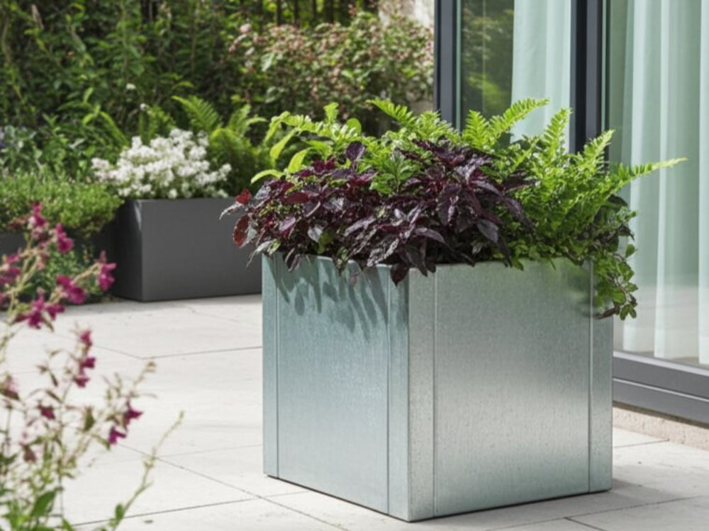 CUBY lav kvadratisk plantekasse i galvaniseret stål med mørk beplantning ved terrasse