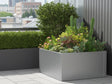 CUBY lav kvadratisk plantekasse i galvaniseret stål med varieret beplantning på urban terrasse