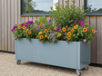 CUBY plantekasse i galvaniseret stål på hjul med farverige haveblomster