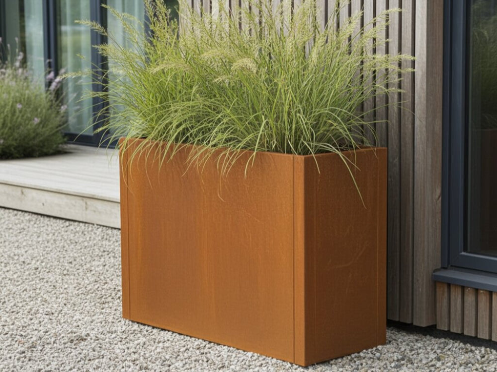 Rektangulær plantekasse i cortenstål fra CUBY med dekorativt prydgræs