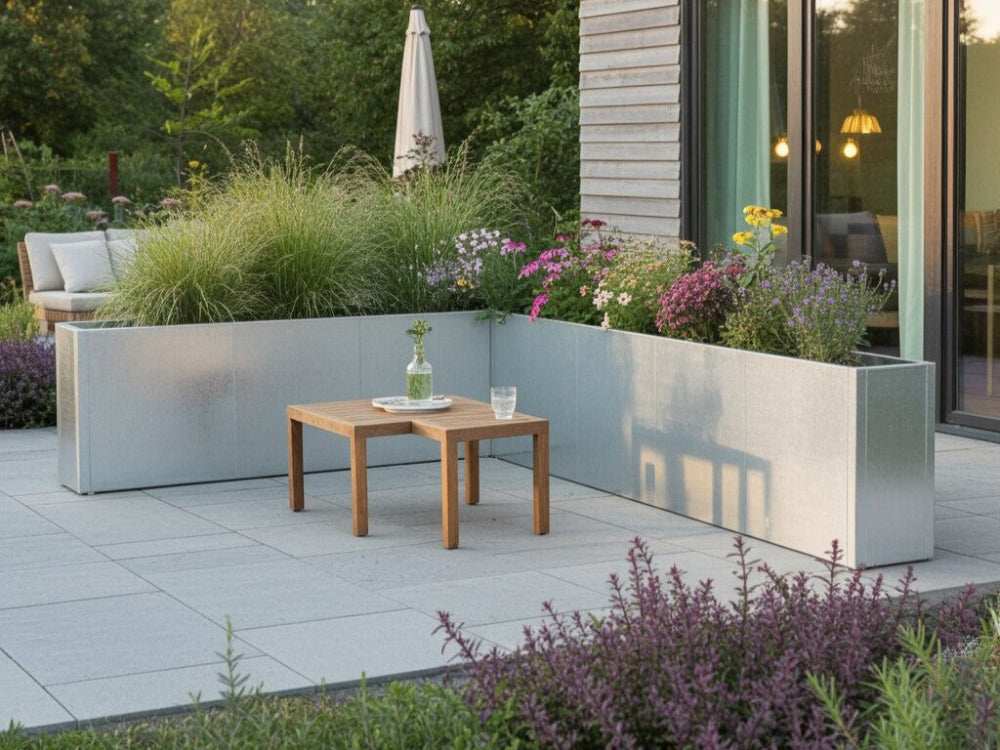 CUBY vinkel plantekasse i galvaniseret stål med prydgræsser og blomster ved terrasse