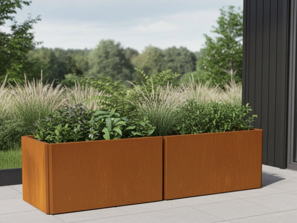 EDGY plantekasse i cortenstål med græsser placeret på terrasse ved facade