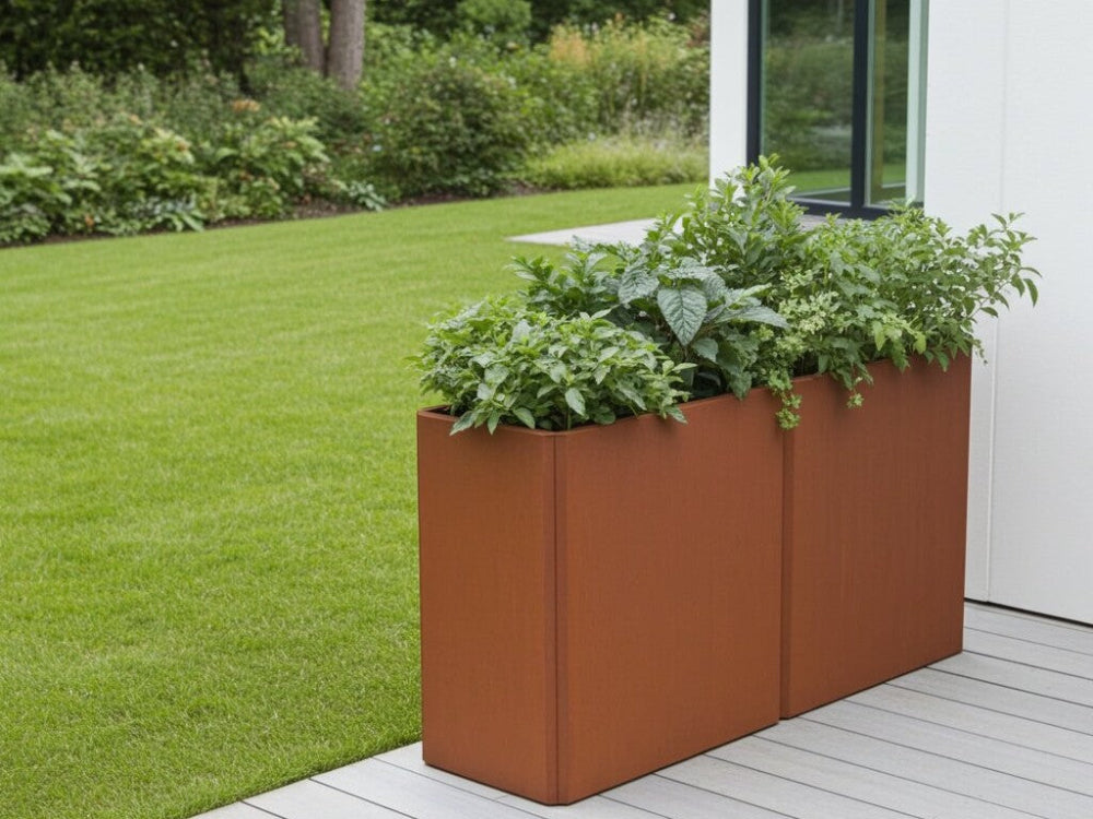 EDGY høj plantekasse i cortenstål med tæt beplantning ved terrasse