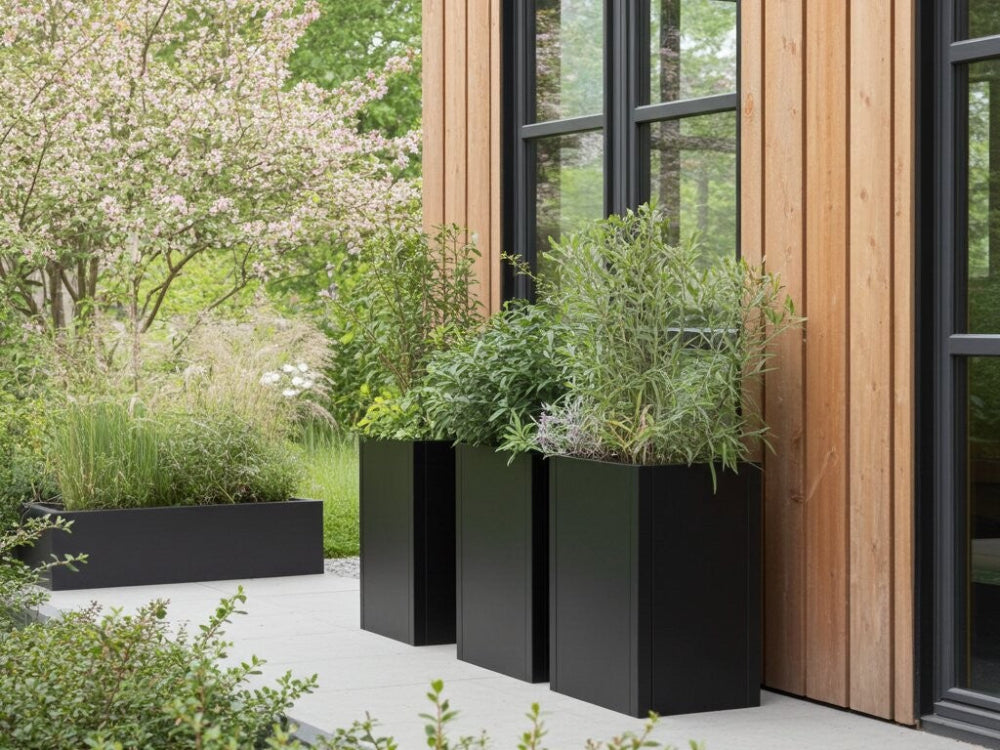 Høje plantekasser i sortlakeret stål ved moderne træfacade