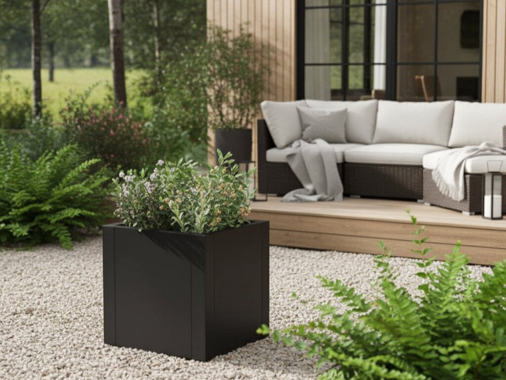 Sort plantekasse i stål med grøn beplantning ved loungeområde på terrasse