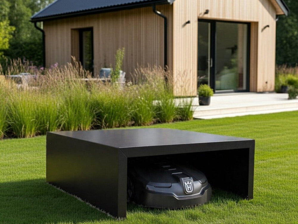 Moderne robotplæneklipper garage i sort stål ved terrasse og bolig