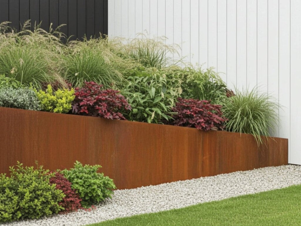 Skrånende støttemur i cortenstål omkring plantebed i moderne have