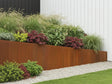 Skrånende støttemur i cortenstål omkring plantebed i moderne have